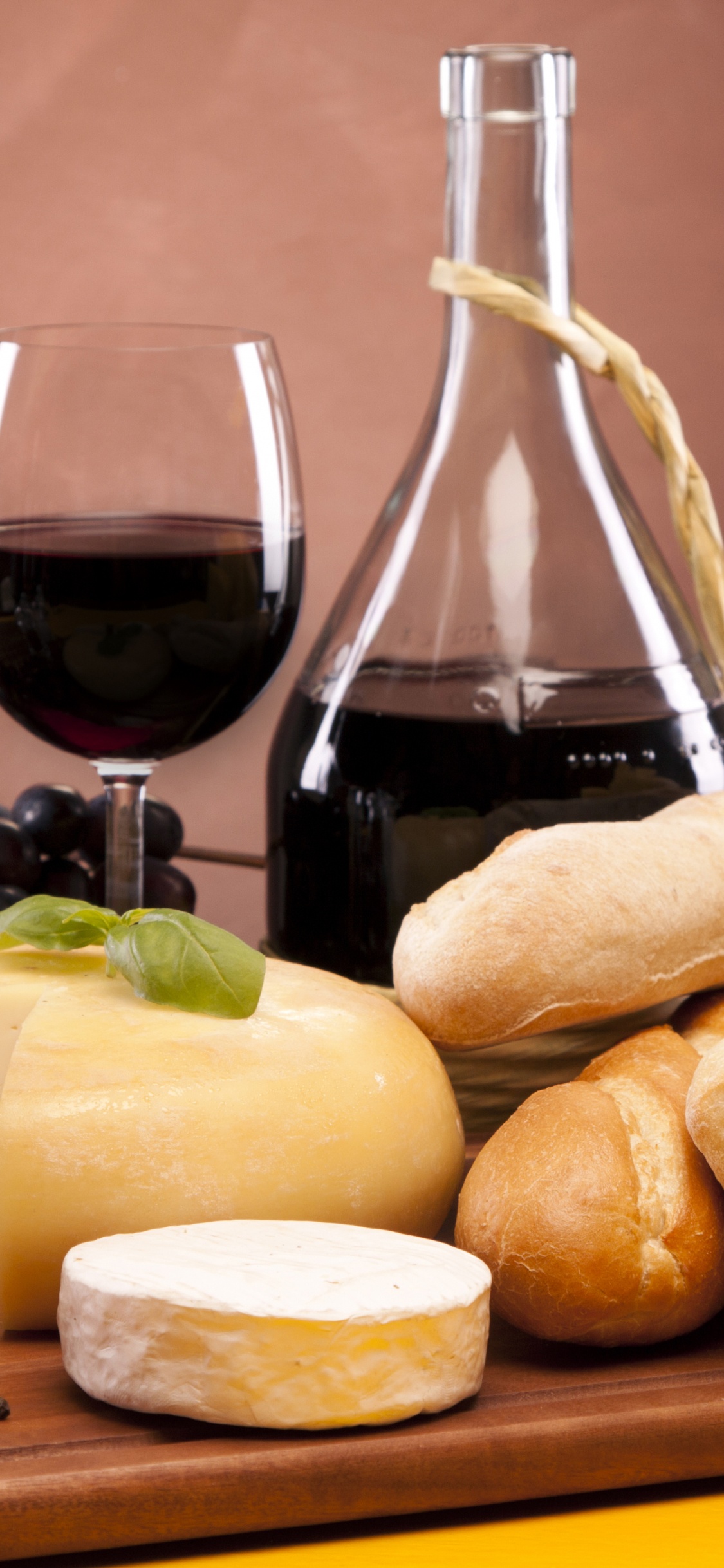 Clear Glass Bottle Beside Bread. Wallpaper in 1125x2436 Resolution