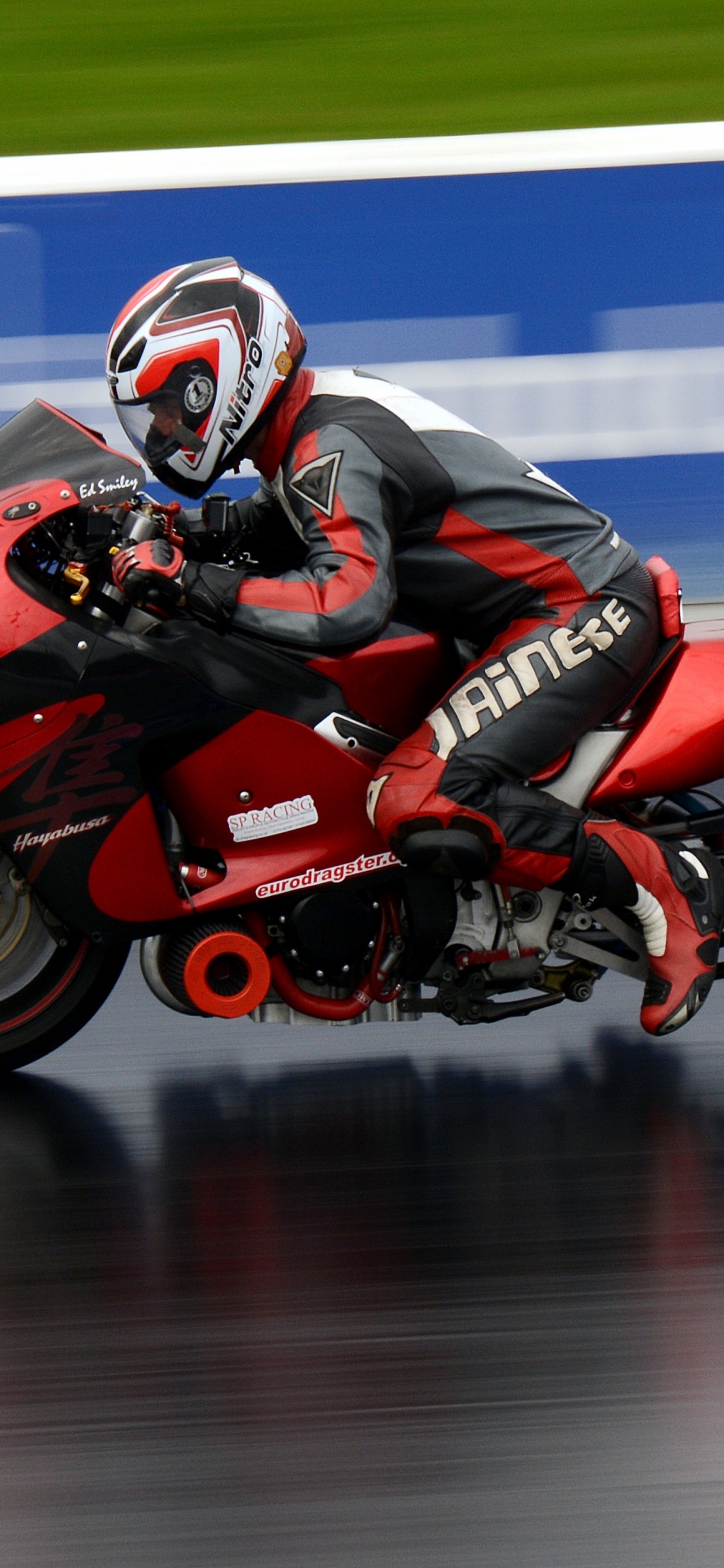 Man in Red and Black Motorcycle Helmet Riding Red Sports Bike. Wallpaper in 1125x2436 Resolution