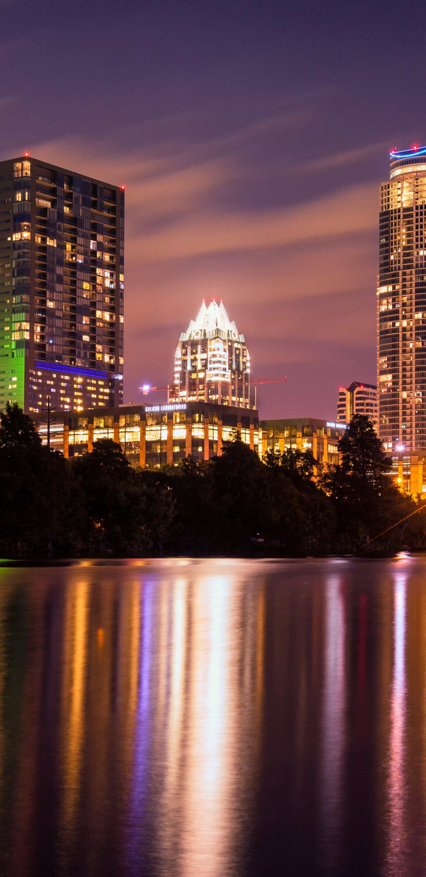 Skyline Der Stadt Über Gewässer Während Der Nacht. Wallpaper in 1440x2960 Resolution