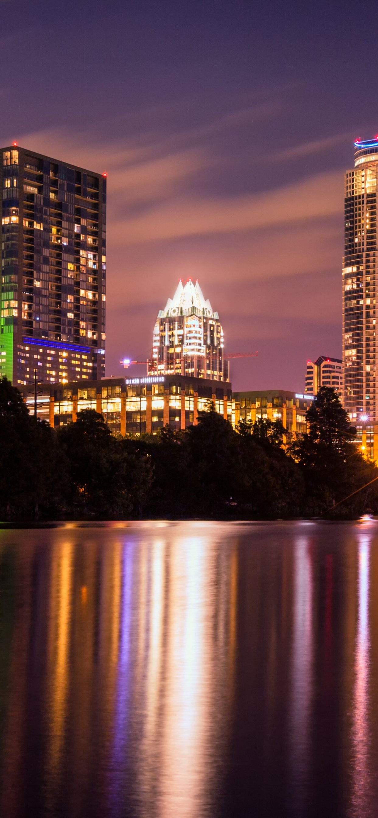 City Skyline Across Body of Water During Night Time. Wallpaper in 1242x2688 Resolution