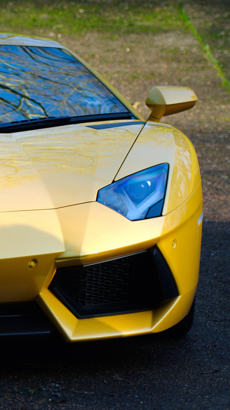 Gelber Lamborghini Aventador Auf Grauer Asphaltstraße Tagsüber. Wallpaper in 750x1334 Resolution
