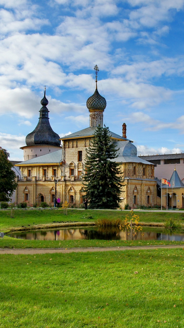 Edificio de Hormigón Marrón Cerca Del Campo de Hierba Verde Bajo Las Nubes Blancas y el Cielo Azul Durante el Día. Wallpaper in 720x1280 Resolution
