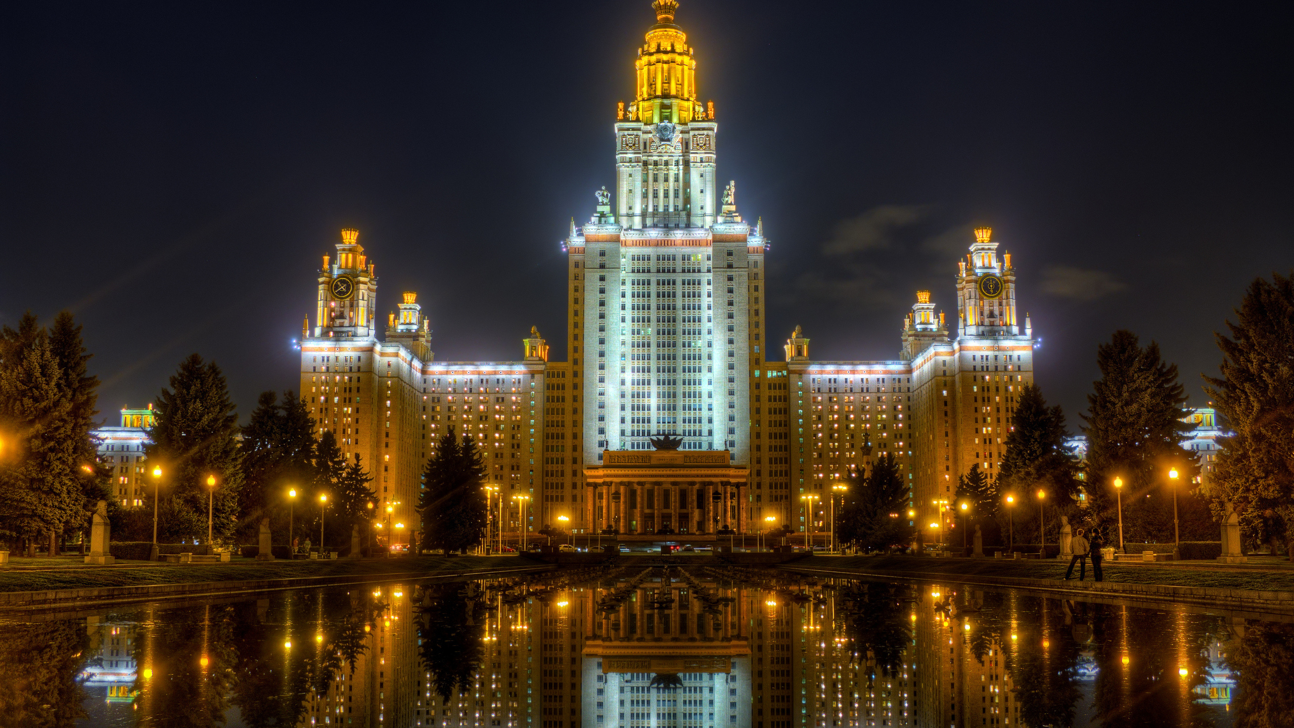 Edificio Iluminado en Blanco y Azul Cerca Del Cuerpo de Agua Durante la Noche. Wallpaper in 2560x1440 Resolution