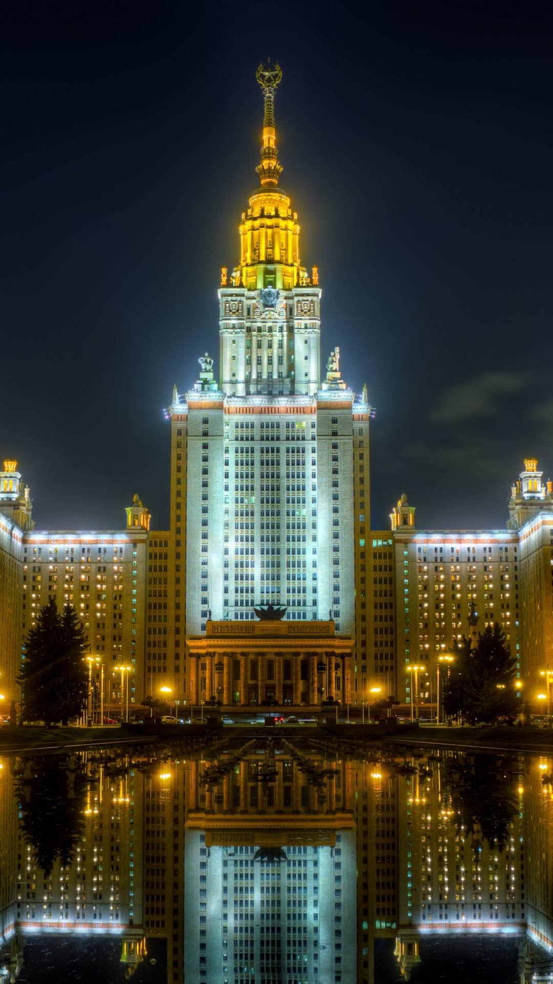 Edificio Iluminado Cerca Del Cuerpo de Agua Durante la Noche.. Wallpaper in 1080x1920 Resolution