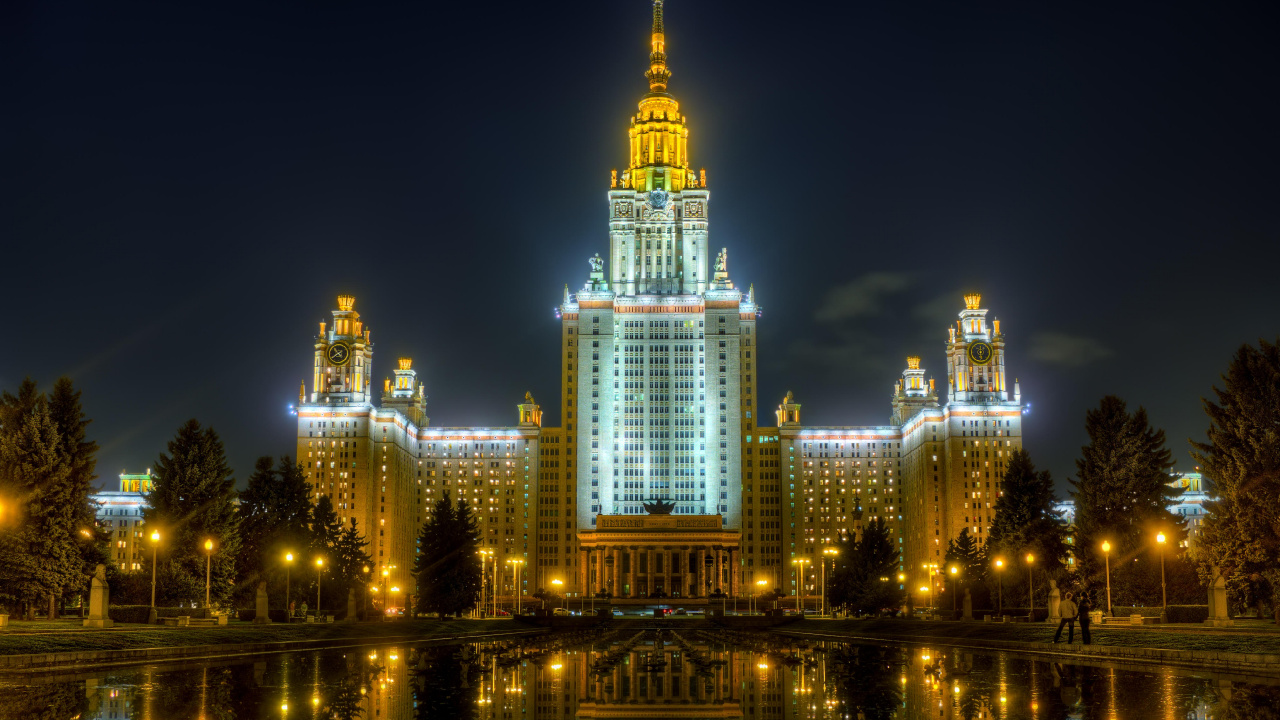 Edificio Iluminado Cerca Del Cuerpo de Agua Durante la Noche.. Wallpaper in 1280x720 Resolution