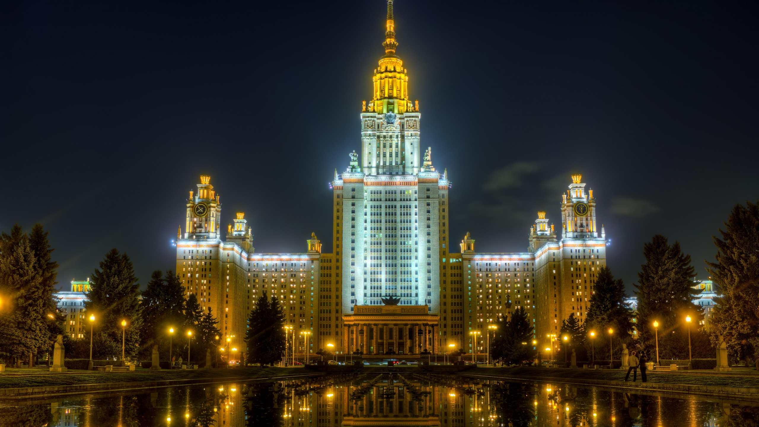 Edificio Iluminado Cerca Del Cuerpo de Agua Durante la Noche.. Wallpaper in 2560x1440 Resolution