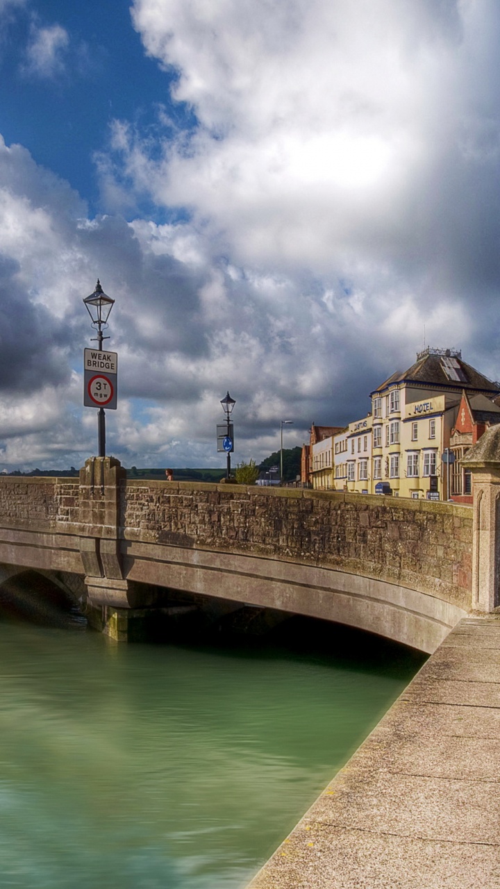 Pont en Béton Brun Sur la Rivière Sous Ciel Bleu et Nuages Blancs Pendant la Journée. Wallpaper in 720x1280 Resolution