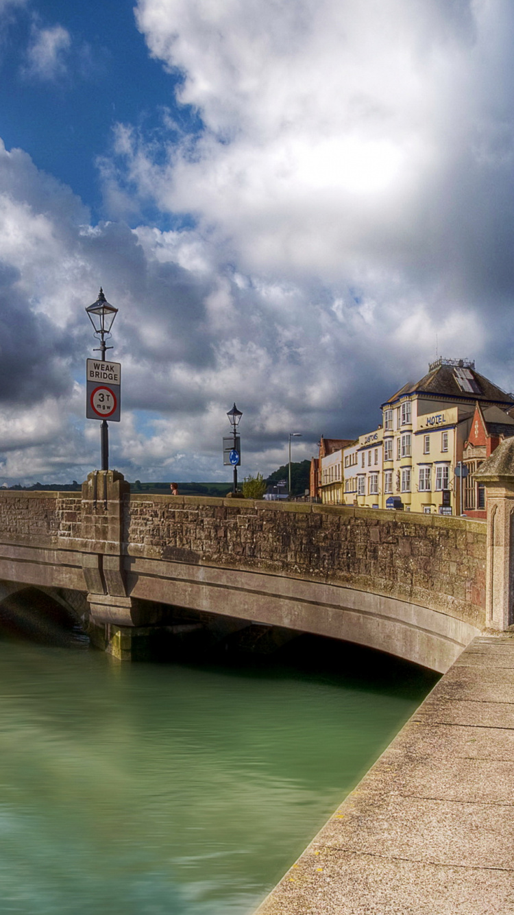 Pont en Béton Brun Sur la Rivière Sous Ciel Bleu et Nuages Blancs Pendant la Journée. Wallpaper in 750x1334 Resolution