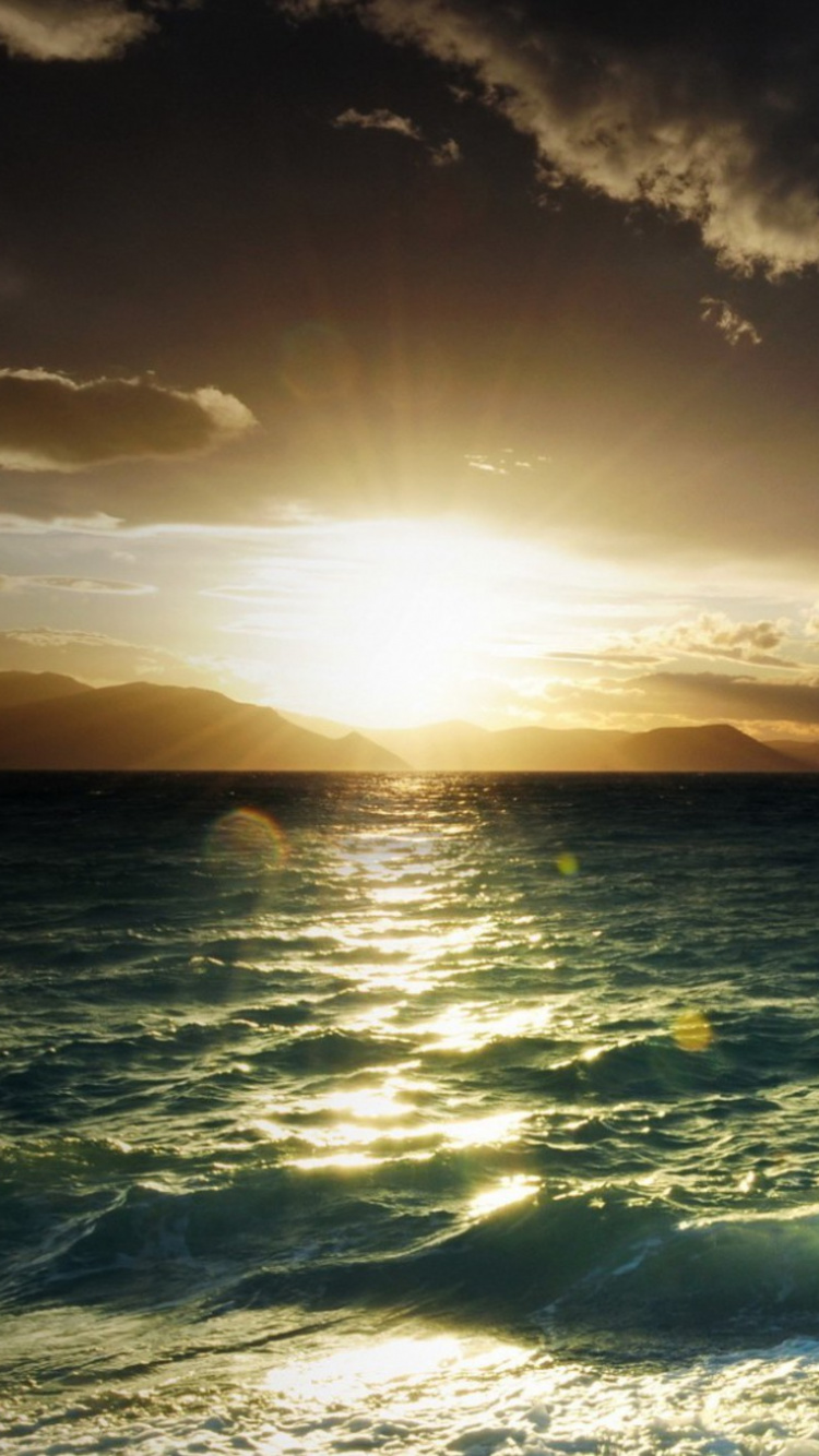 Ocean Waves Crashing on Shore During Sunset. Wallpaper in 750x1334 Resolution