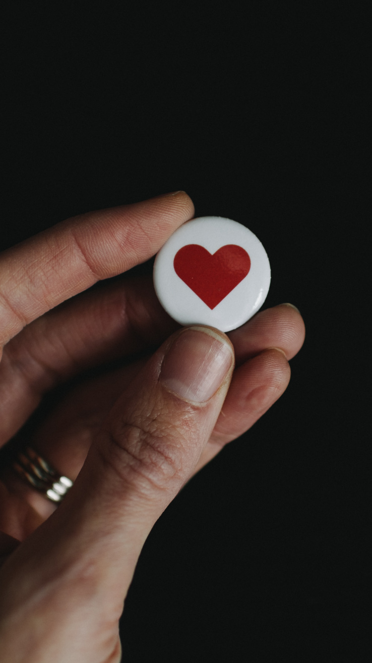 Personne Tenant un Ornement en Forme de Coeur Blanc et Rouge. Wallpaper in 750x1334 Resolution