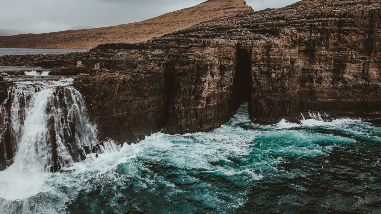 Brauner Felsiger Berg Neben Gewässer Tagsüber During. Wallpaper in 1280x720 Resolution