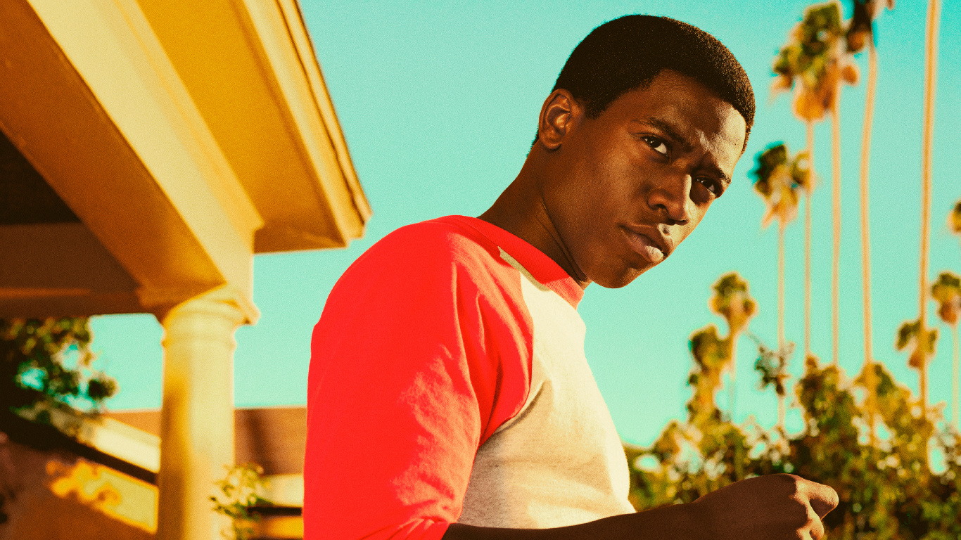 Man in White and Red Crew Neck T-shirt Standing Near Yellow Concrete Building During Daytime. Wallpaper in 1366x768 Resolution