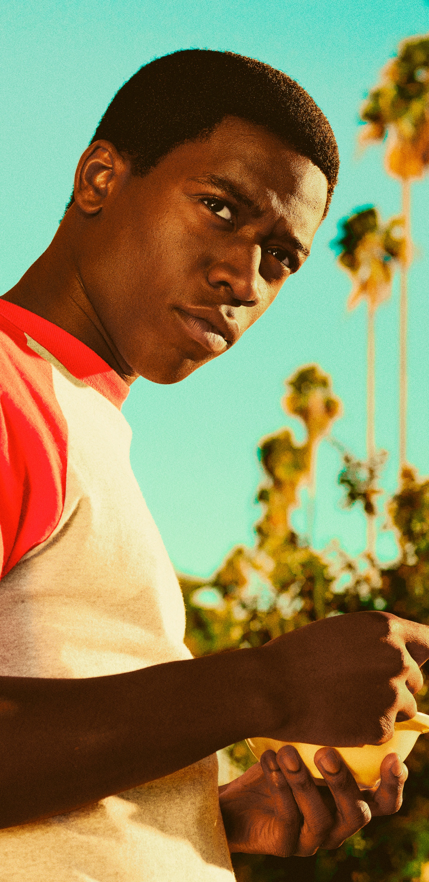 Man in White and Red Crew Neck T-shirt Standing Near Yellow Concrete Building During Daytime. Wallpaper in 1440x2960 Resolution