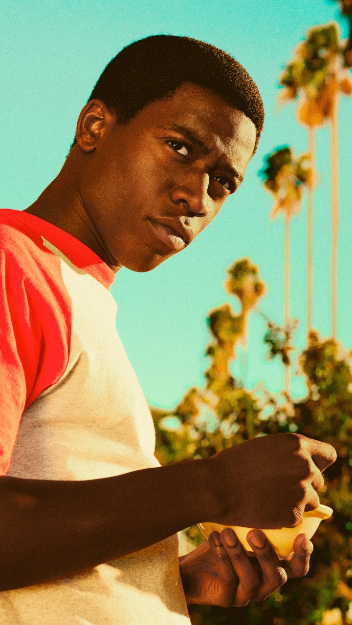 Man in White and Red Crew Neck T-shirt Standing Near Yellow Concrete Building During Daytime. Wallpaper in 720x1280 Resolution