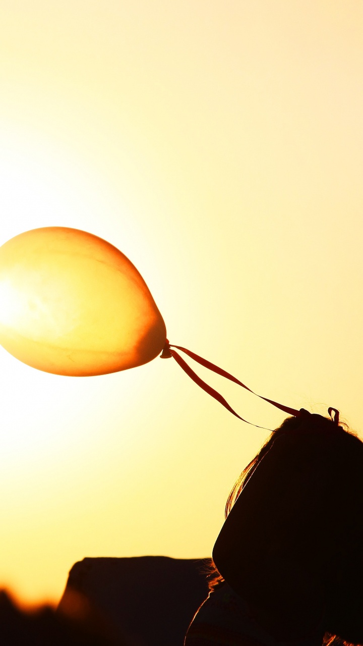 Silhouette of Man Holding Balloons During Sunset. Wallpaper in 720x1280 Resolution