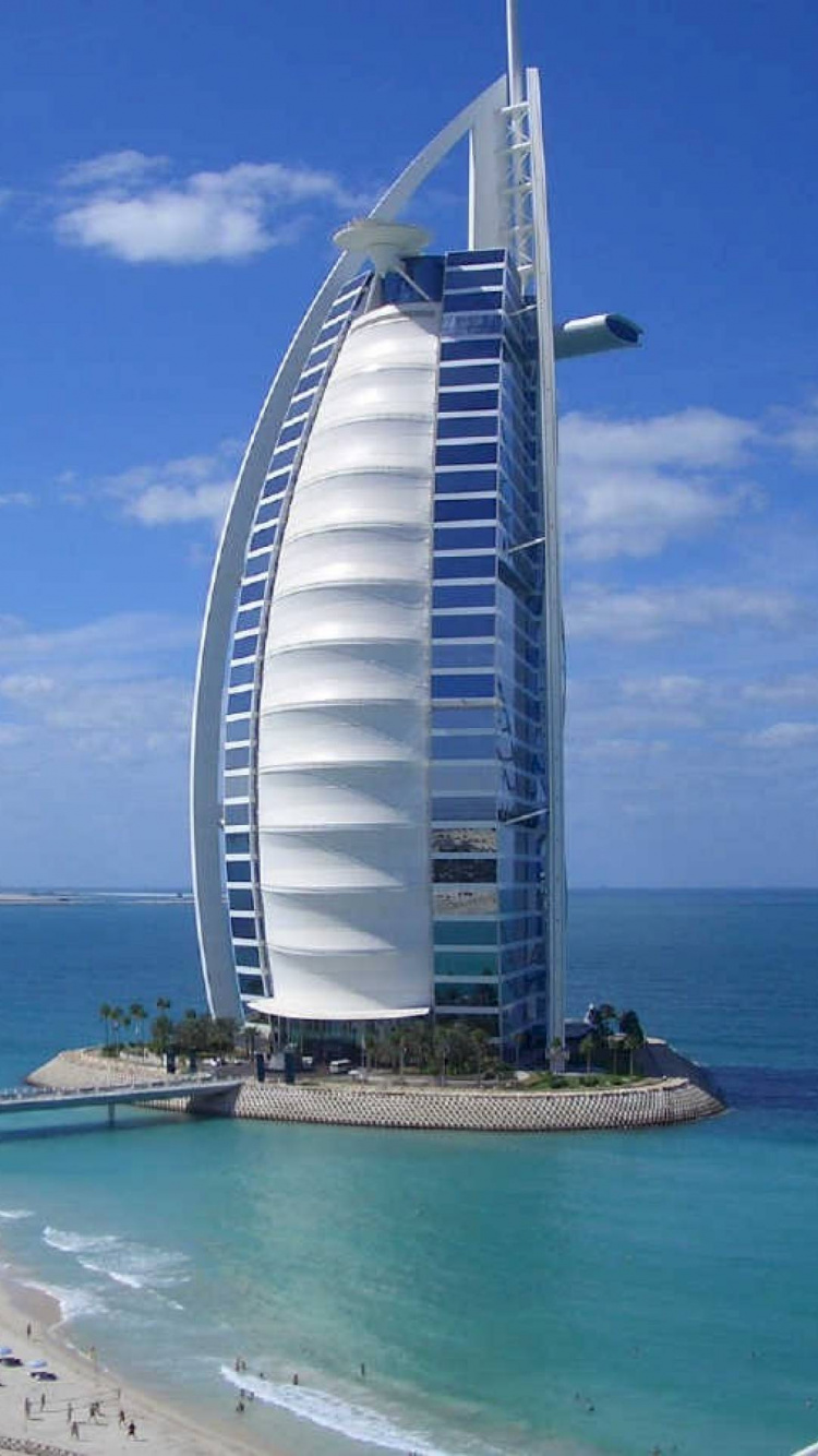 White and Blue Building Near Body of Water During Daytime. Wallpaper in 750x1334 Resolution