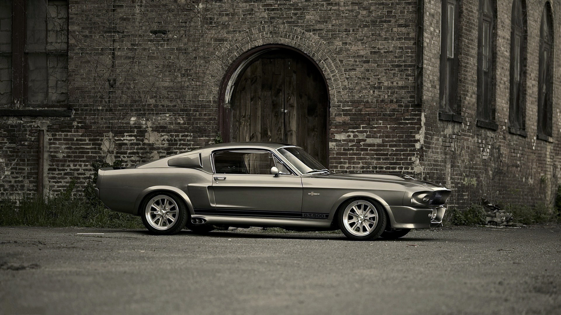 Grayscale Photo of Coupe Parked Beside Brick Wall. Wallpaper in 1920x1080 Resolution