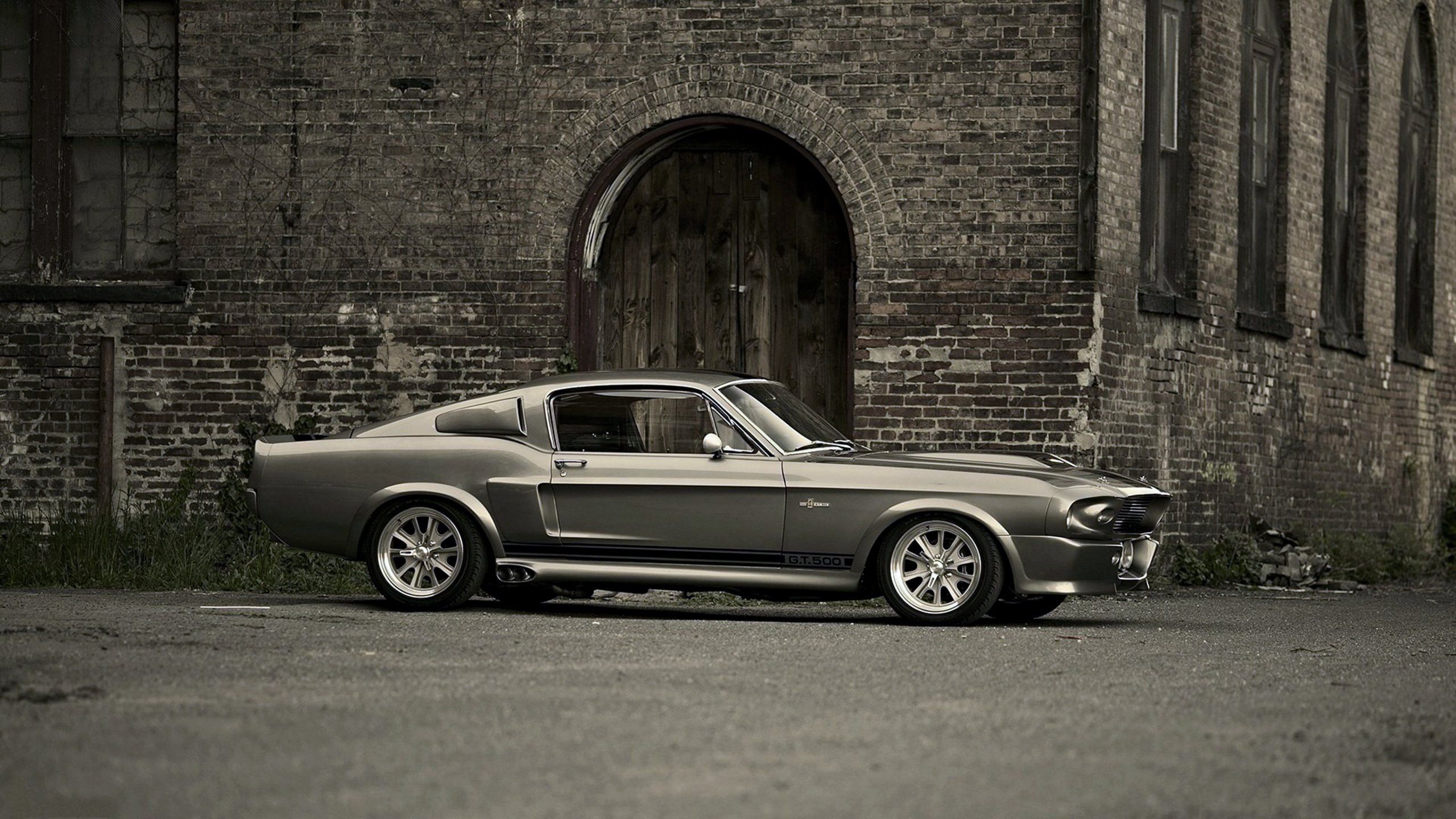 Grayscale Photo of Coupe Parked Beside Brick Wall. Wallpaper in 2560x1440 Resolution