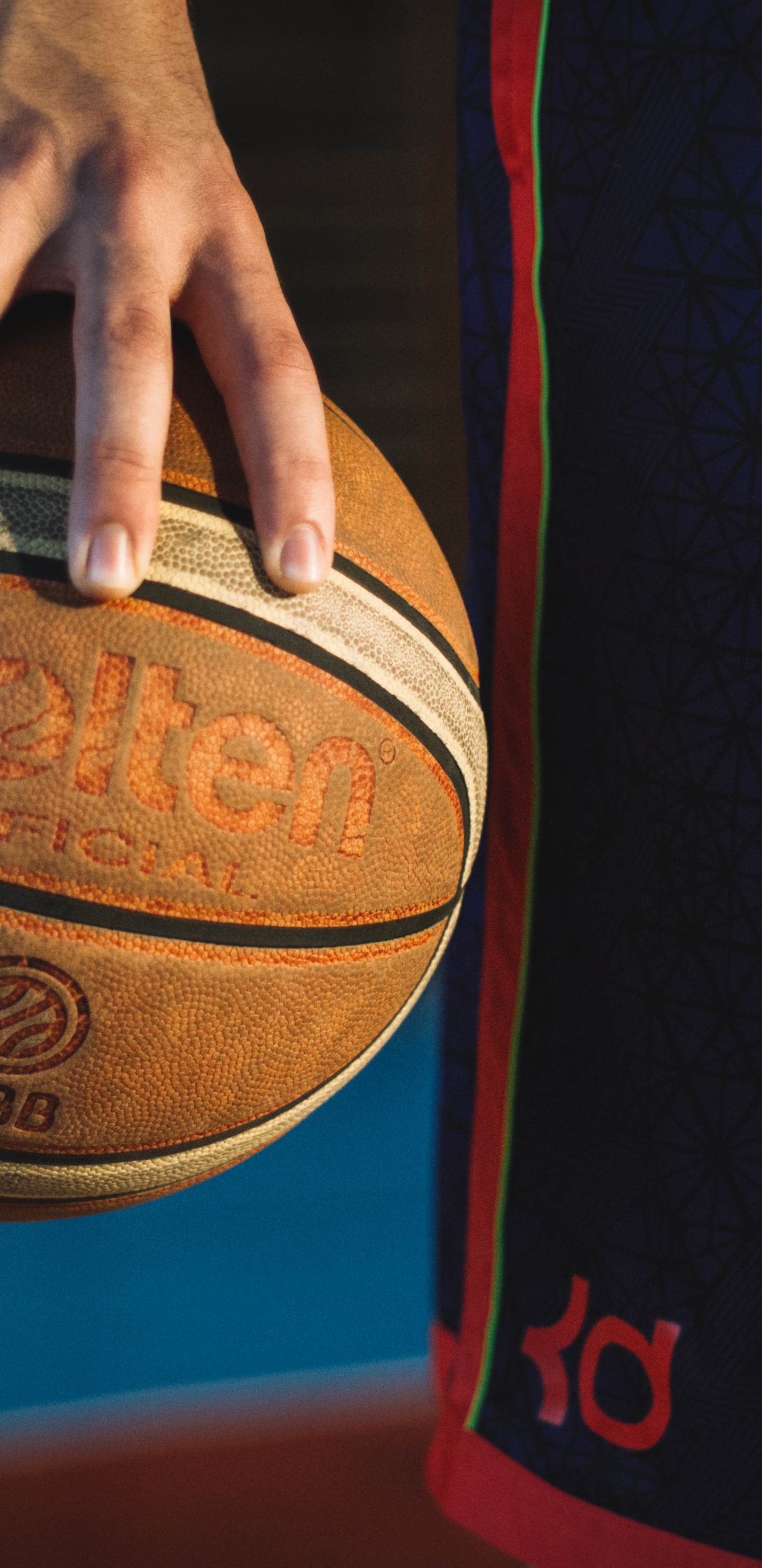 Person Holding Red and Black Basketball. Wallpaper in 1440x2960 Resolution