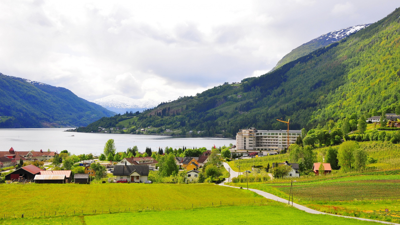 White Concrete Building Near Green Grass Field and Body of Water During Daytime. Wallpaper in 1280x720 Resolution