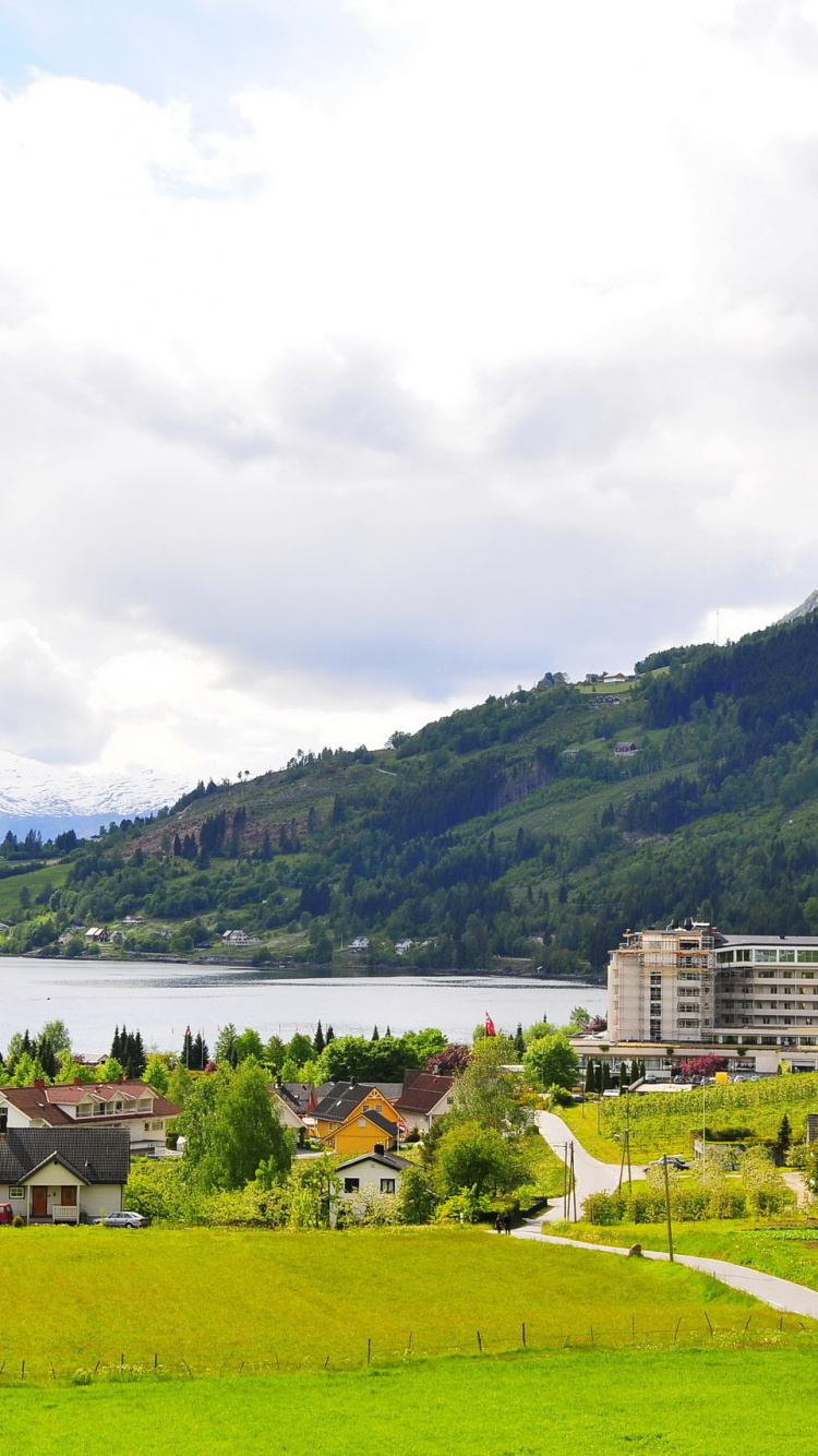 White Concrete Building Near Green Grass Field and Body of Water During Daytime. Wallpaper in 750x1334 Resolution