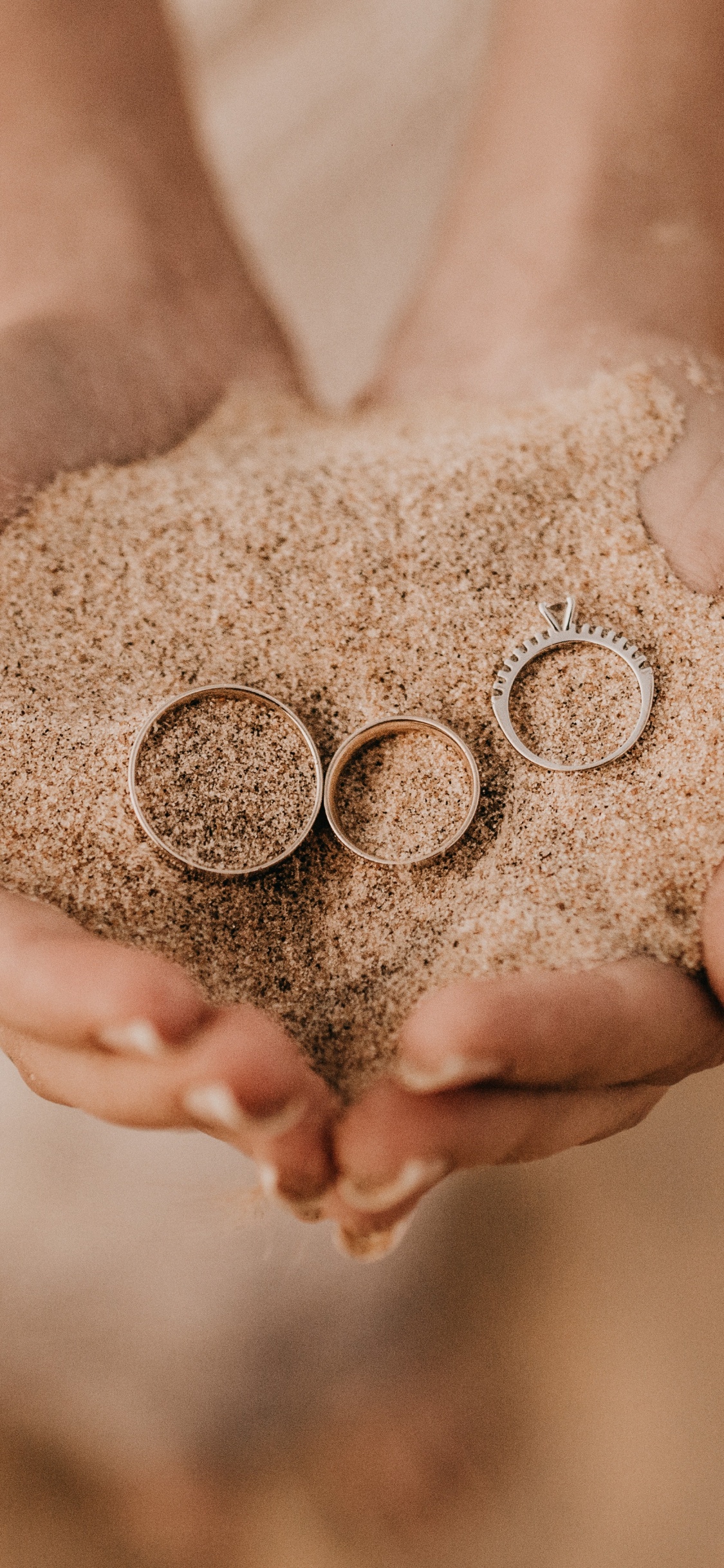 Person Mit Braunem Sand Auf Weißem Textil. Wallpaper in 1125x2436 Resolution