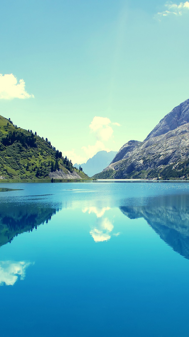 Green Mountains Beside Blue Lake Under Blue Sky During Daytime. Wallpaper in 750x1334 Resolution