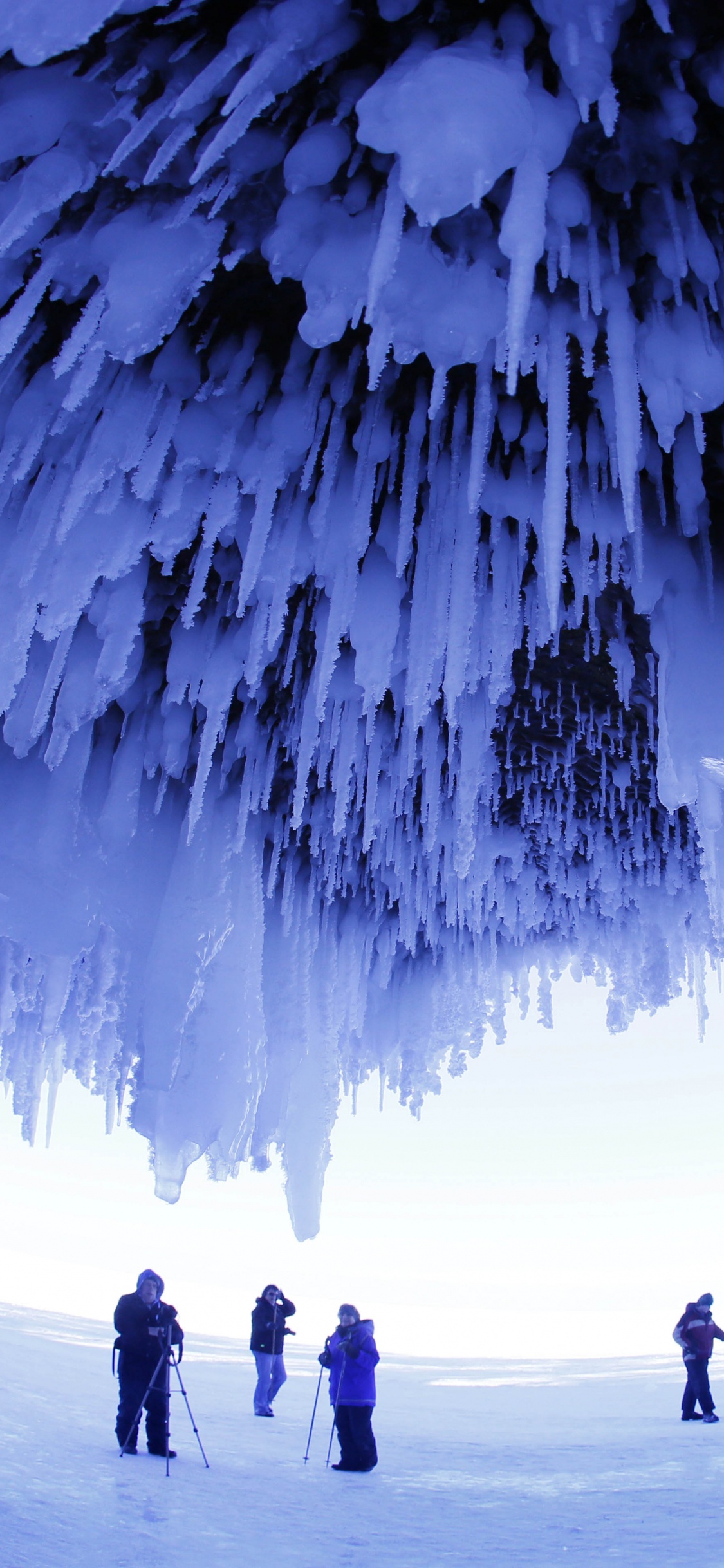 Silhouette de Personnes Marchant Sur un Sol Couvert de Neige. Wallpaper in 1125x2436 Resolution