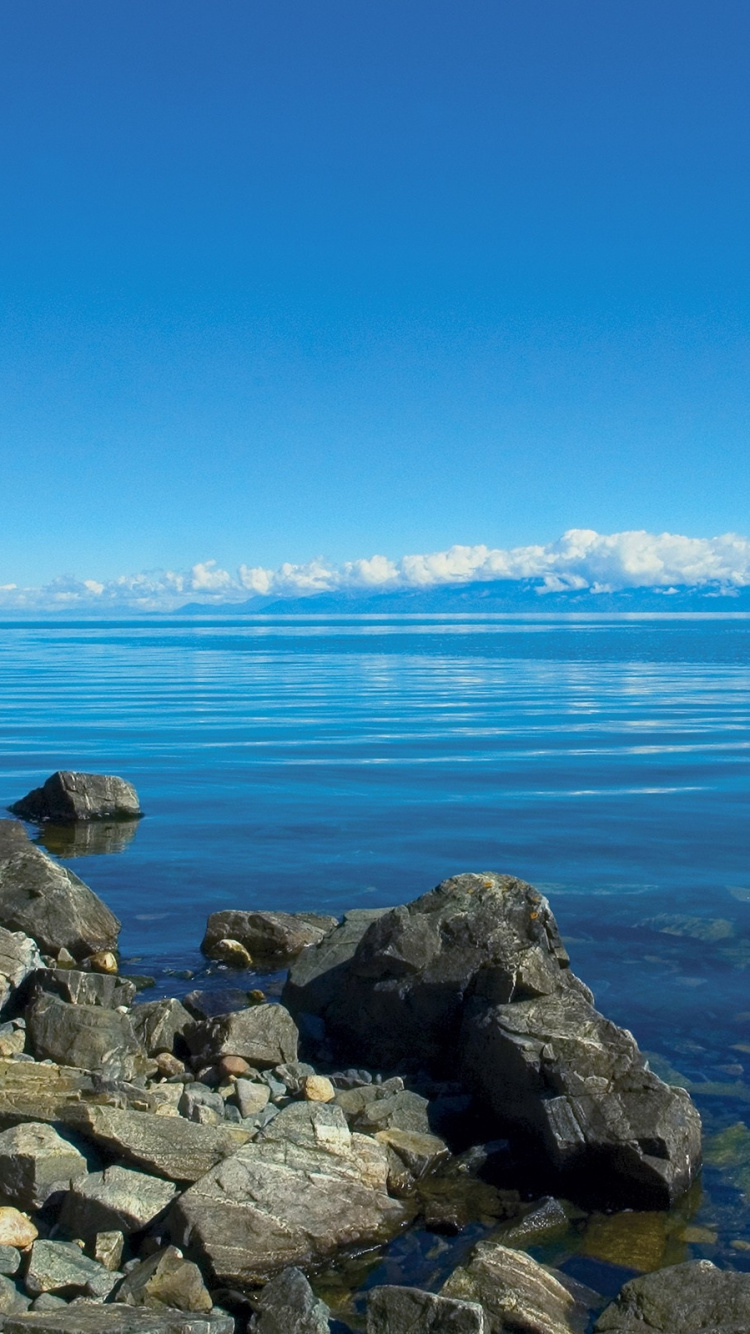Gray Rocks Near Body of Water During Daytime. Wallpaper in 750x1334 Resolution