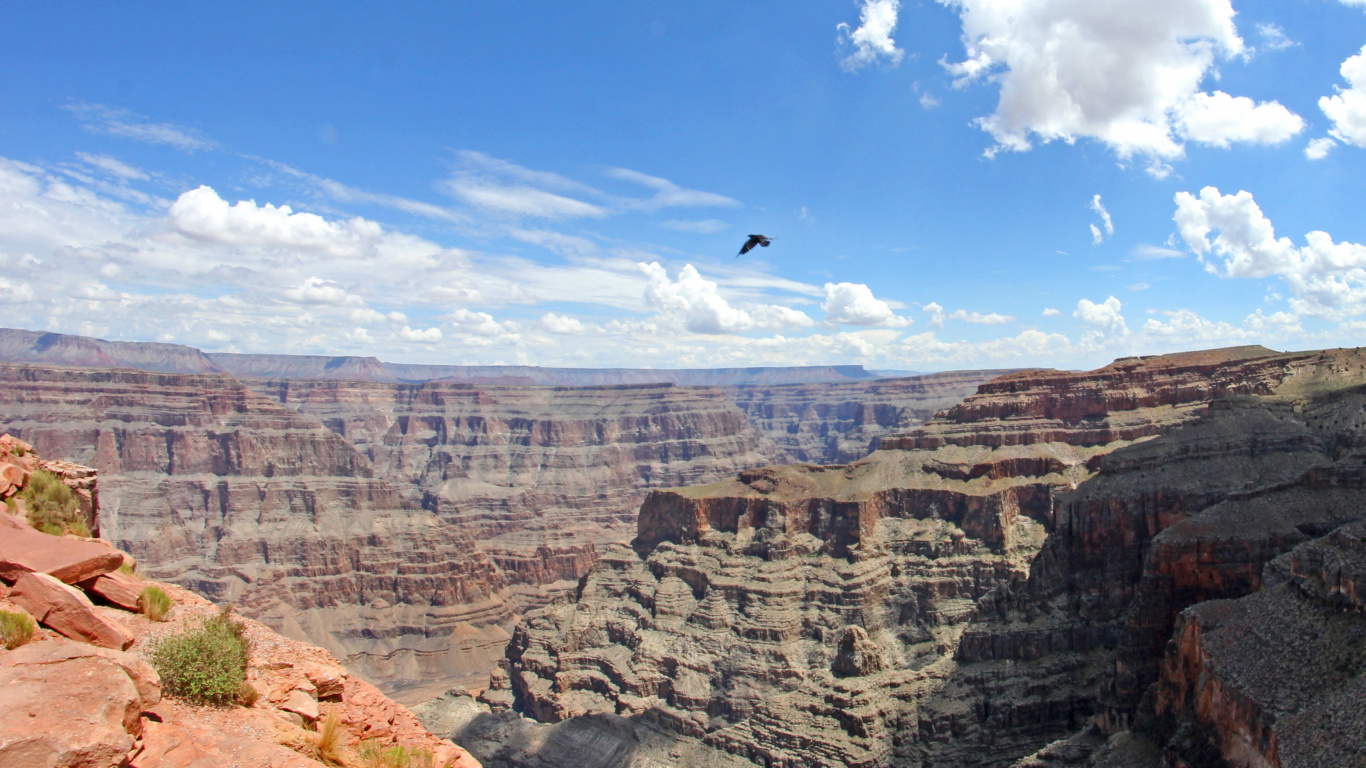 Person in Black Jacket Standing on Brown Rock Formation During Daytime. Wallpaper in 1366x768 Resolution