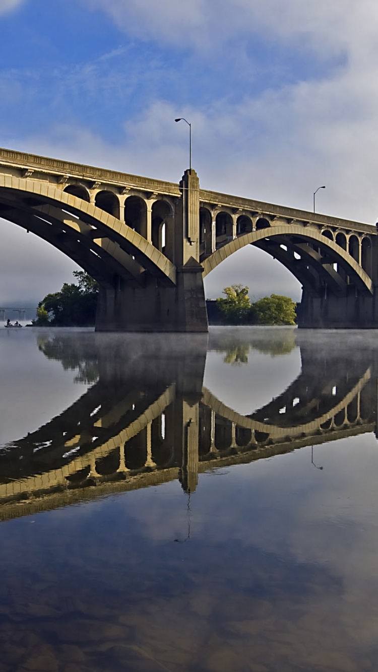 Brown Concrete Bridge Over River Under Blue Sky During Daytime. Wallpaper in 750x1334 Resolution