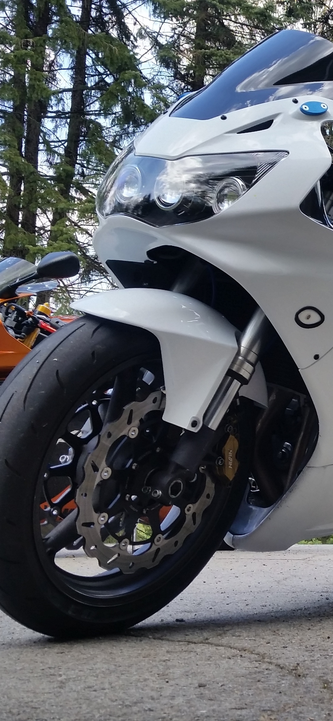 White and Black Sports Bike Parked on Dirt Road During Daytime. Wallpaper in 1125x2436 Resolution