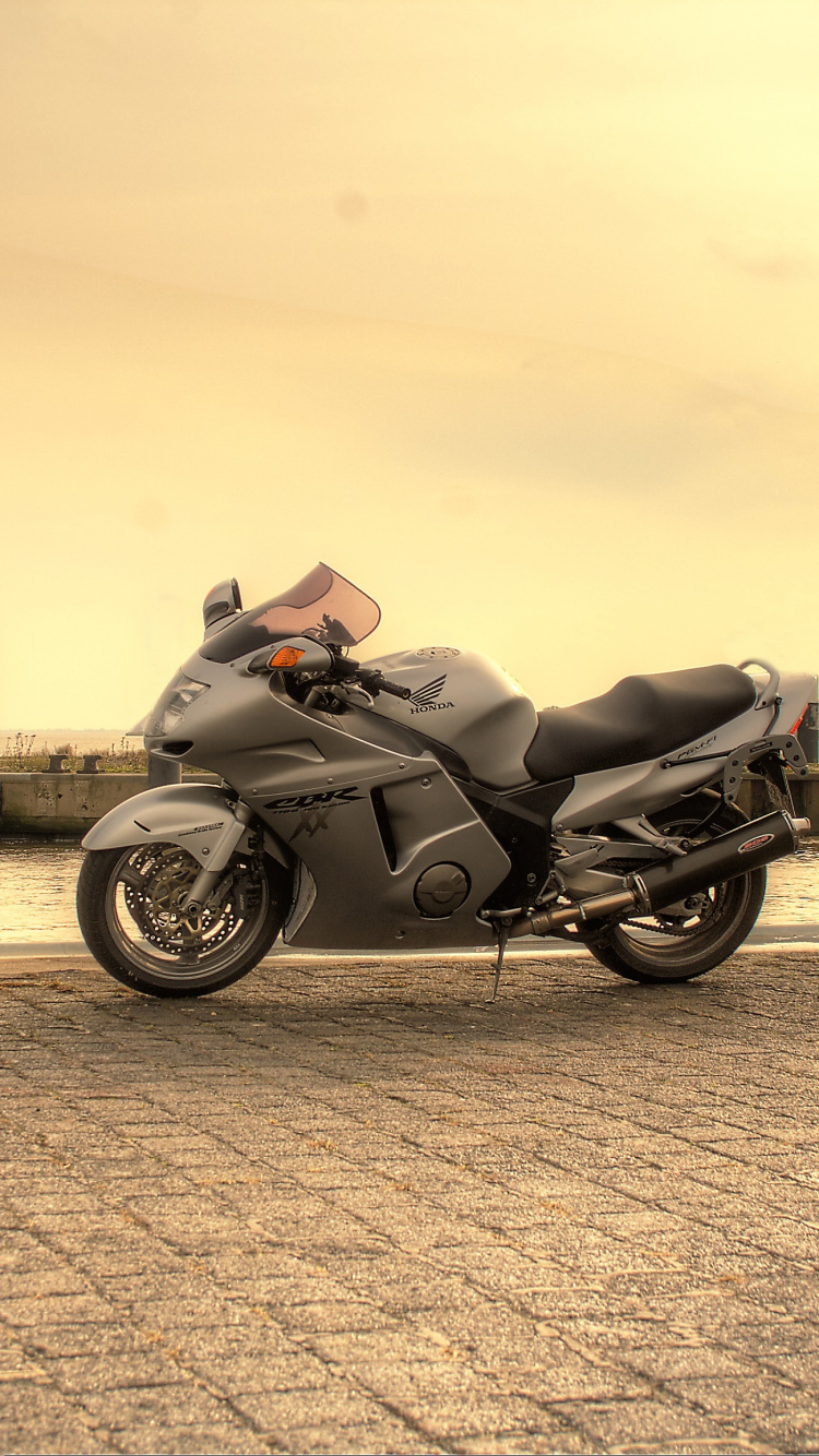 Schwarzes Motorrad Tagsüber Auf Grauem Betonpflaster Geparkt. Wallpaper in 750x1334 Resolution