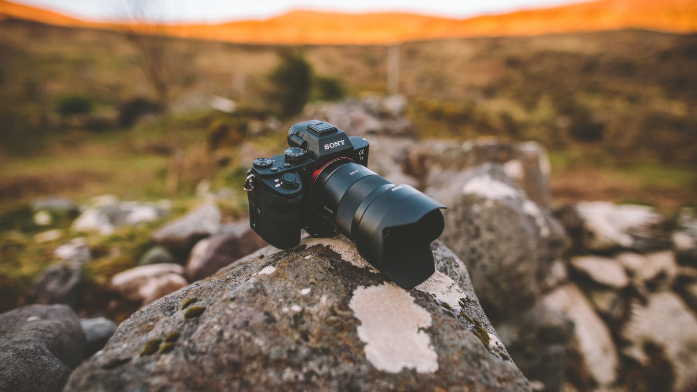 Black Dslr Camera on Rock. Wallpaper in 1366x768 Resolution