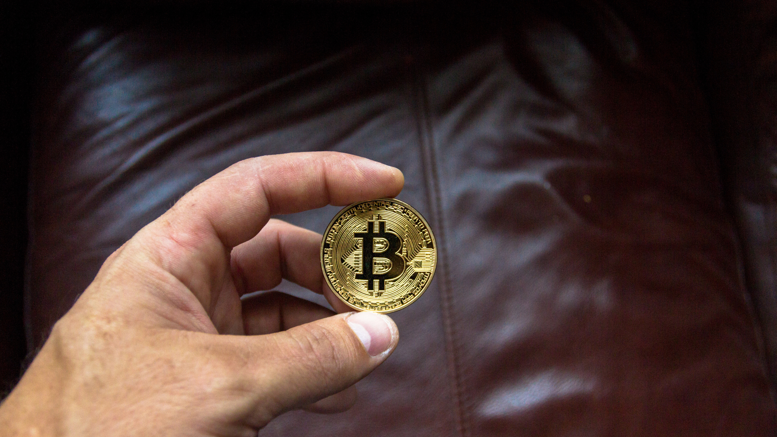 Gold Round Coin on Brown Leather Textile. Wallpaper in 2560x1440 Resolution