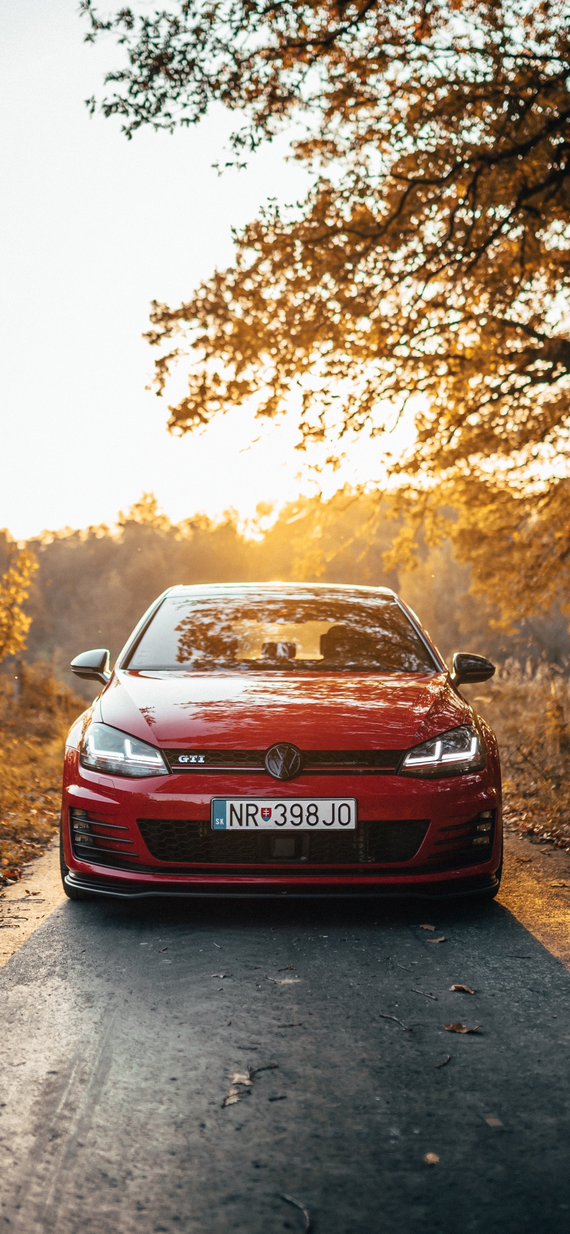 Coche Rojo en Camino de Tierra Durante el Día. Wallpaper in 1125x2436 Resolution