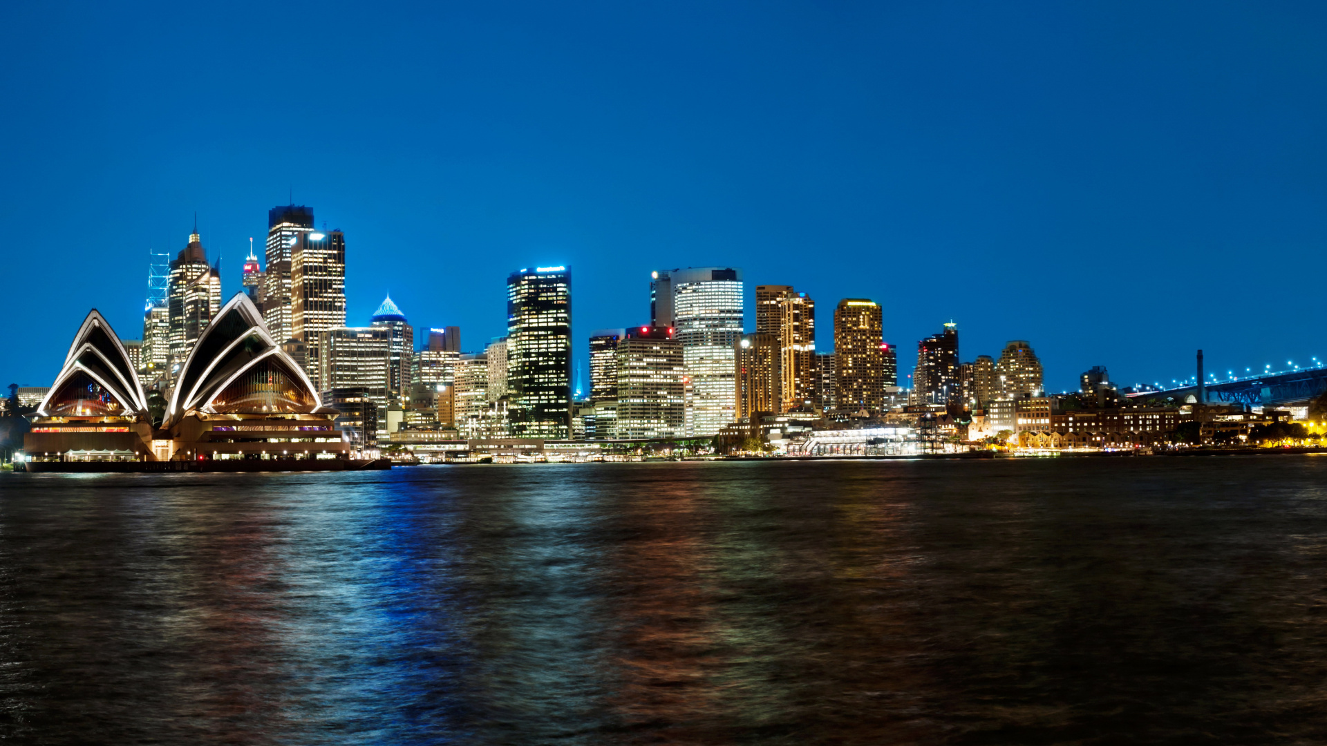 Skyline Der Stadt Über Gewässer Während Der Nacht. Wallpaper in 1920x1080 Resolution