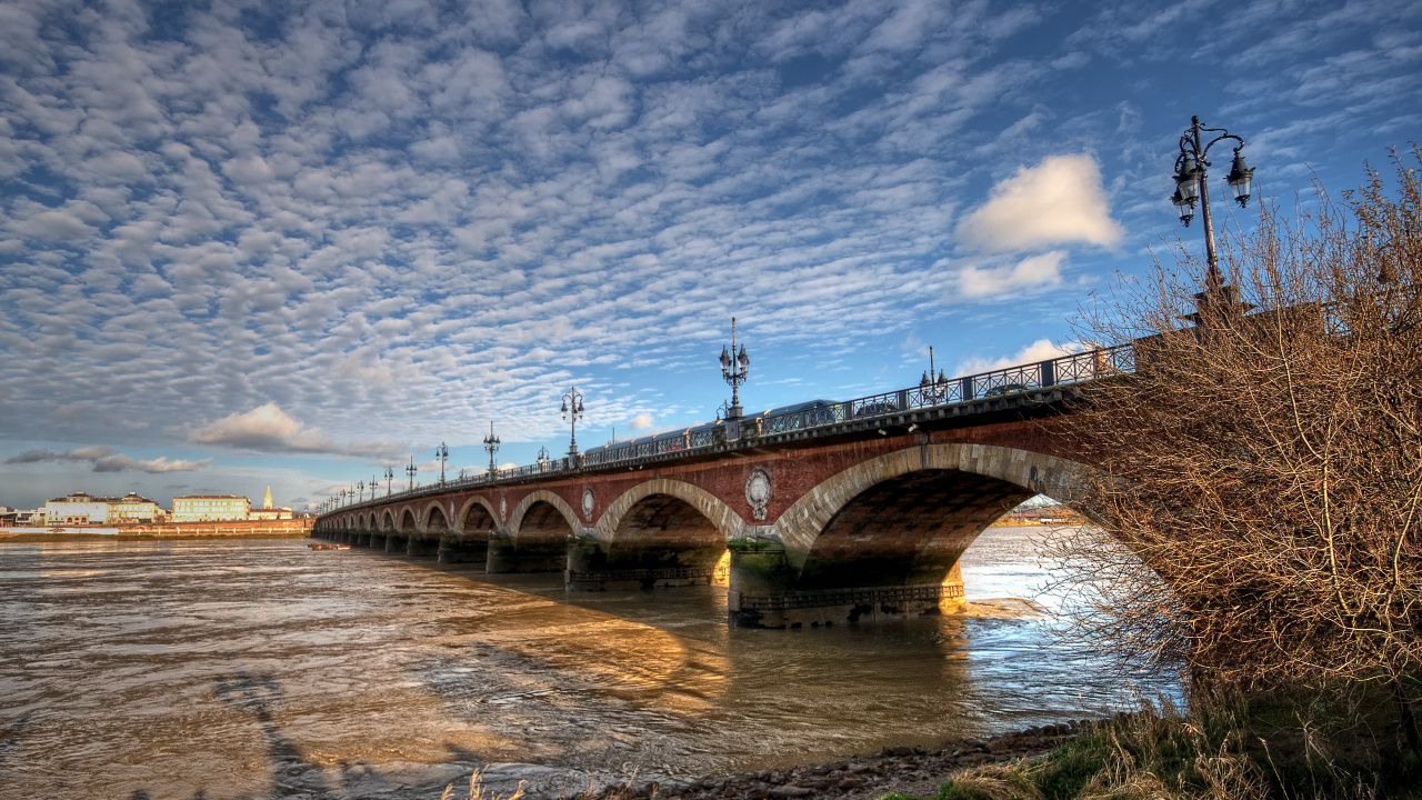 Brown Concrete Bridge Over River Under Blue Sky During Daytime. Wallpaper in 1280x720 Resolution