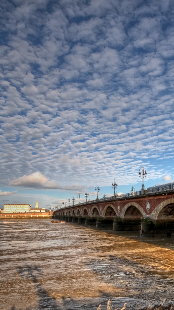 Brown Concrete Bridge Over River Under Blue Sky During Daytime. Wallpaper in 720x1280 Resolution
