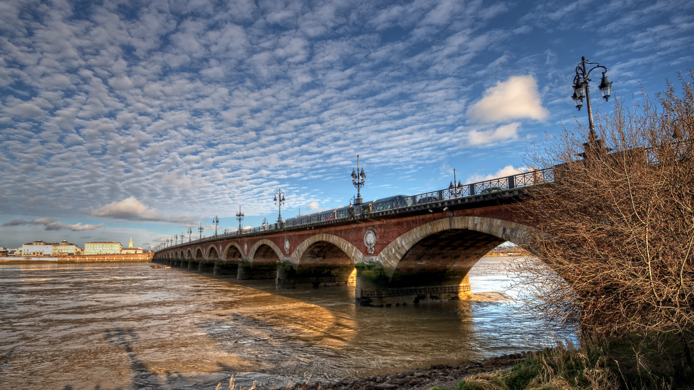 Puente de Hormigón Marrón Sobre el Río Bajo un Cielo Azul Durante el Día. Wallpaper in 1366x768 Resolution