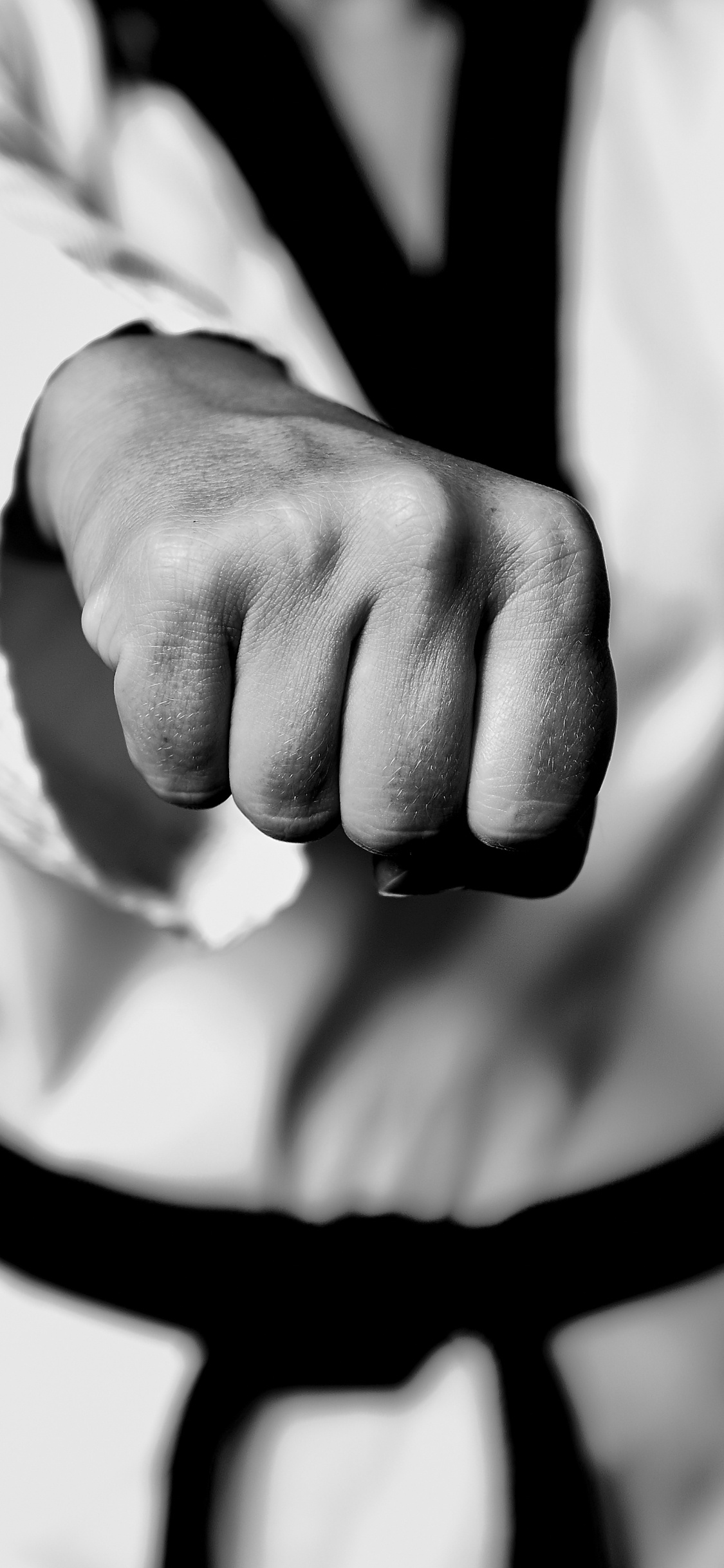 Grayscale Photo of Person Holding Black Strap. Wallpaper in 1125x2436 Resolution