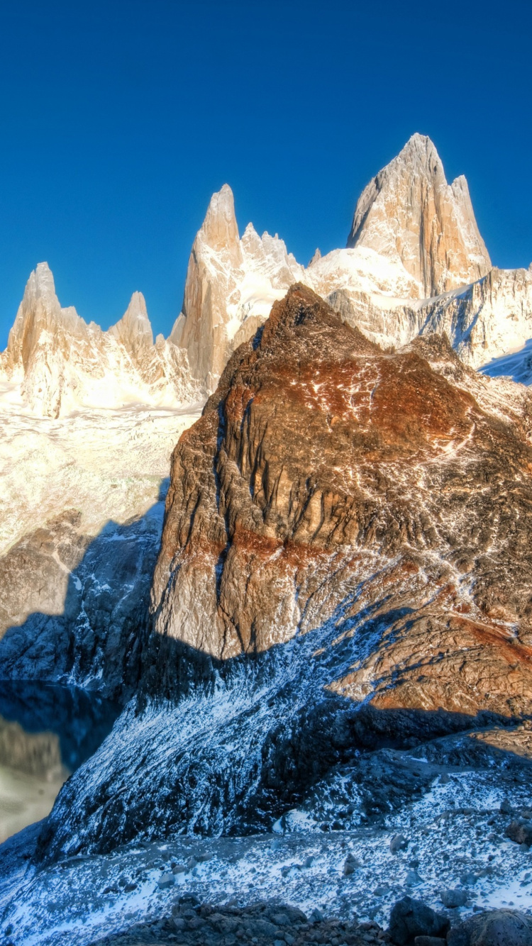 Brown and White Mountain Range Under Blue Sky During Daytime. Wallpaper in 750x1334 Resolution