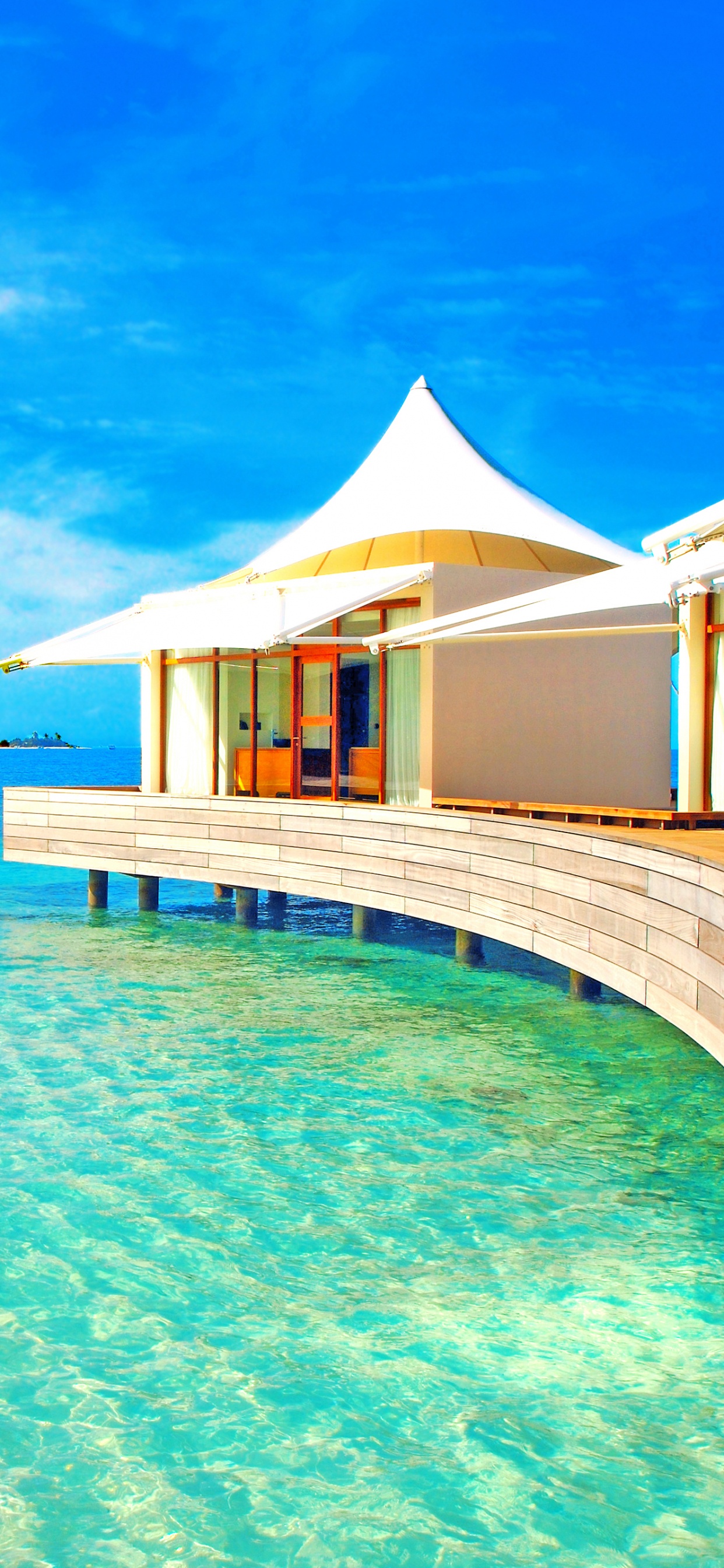 Brown Wooden Beach House on Blue Sea Under Blue Sky During Daytime. Wallpaper in 1242x2688 Resolution