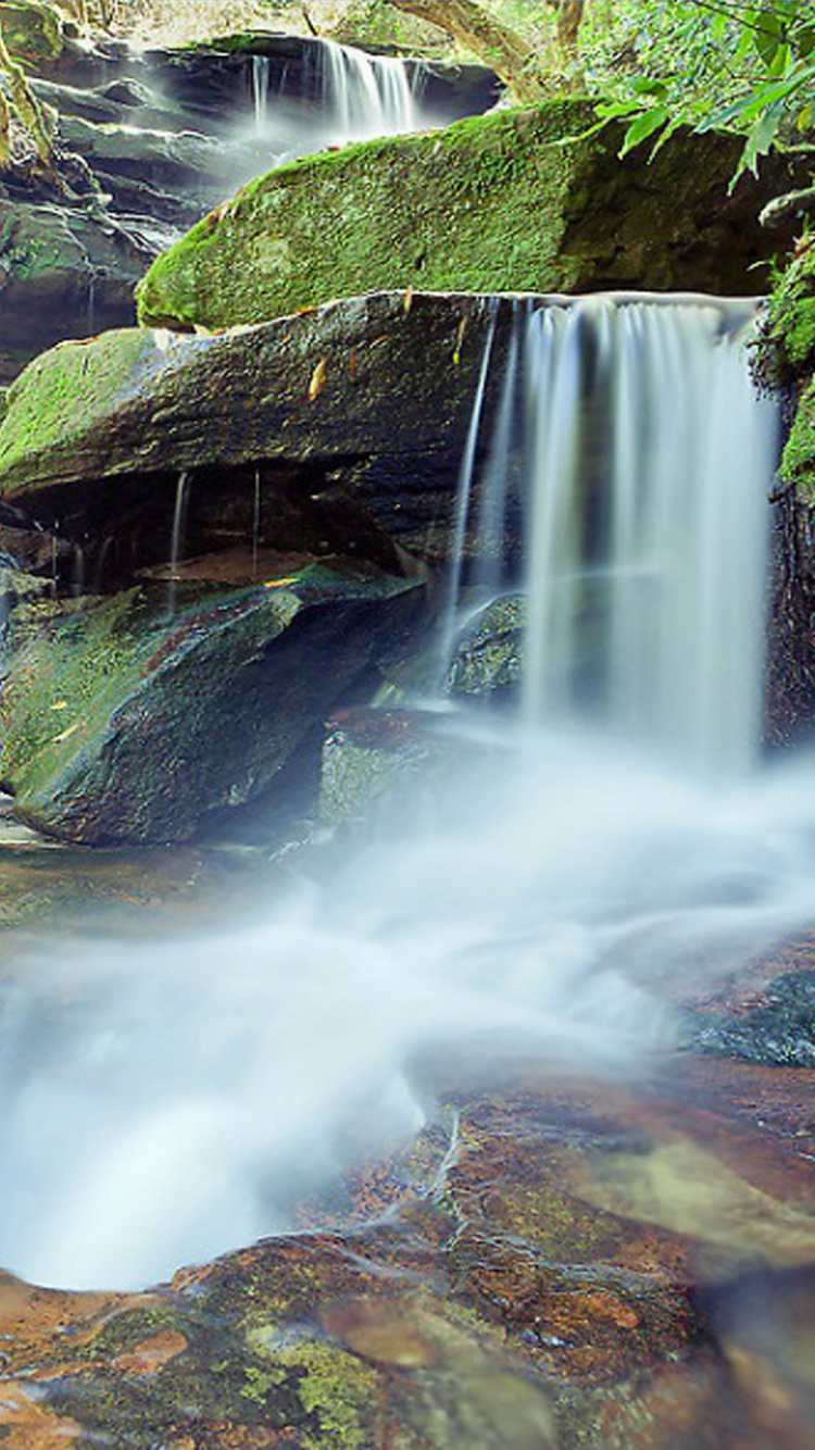 el Agua Cae Sobre la Montaña Rocosa Marrón. Wallpaper in 750x1334 Resolution