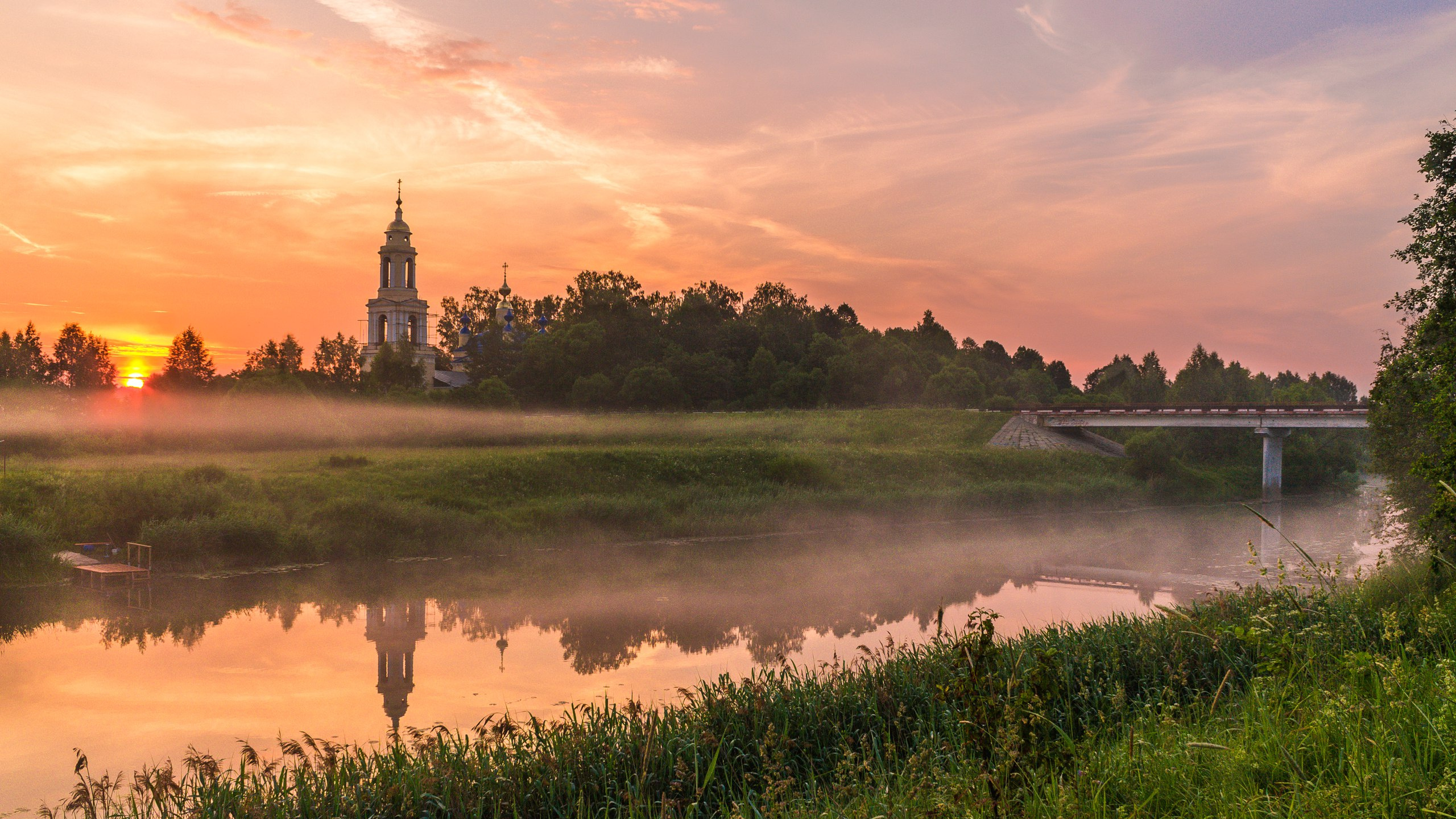 Grüne Wiese in Der Nähe Von Gewässern Während Des Sonnenuntergangs. Wallpaper in 2560x1440 Resolution