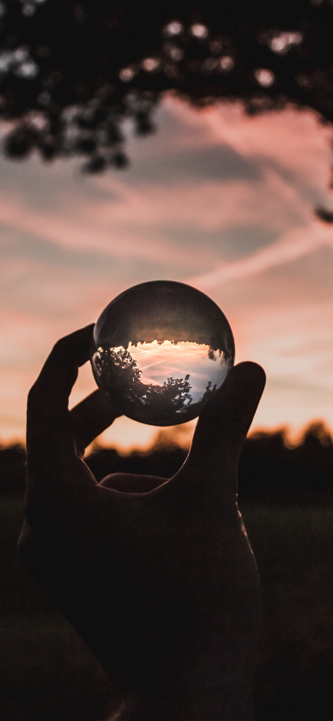 Silhouette of Person Holding Ball During Sunset. Wallpaper in 1125x2436 Resolution