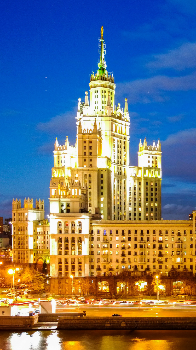 Edificio de Hormigón Blanco Cerca Del Cuerpo de Agua Durante la Noche. Wallpaper in 750x1334 Resolution