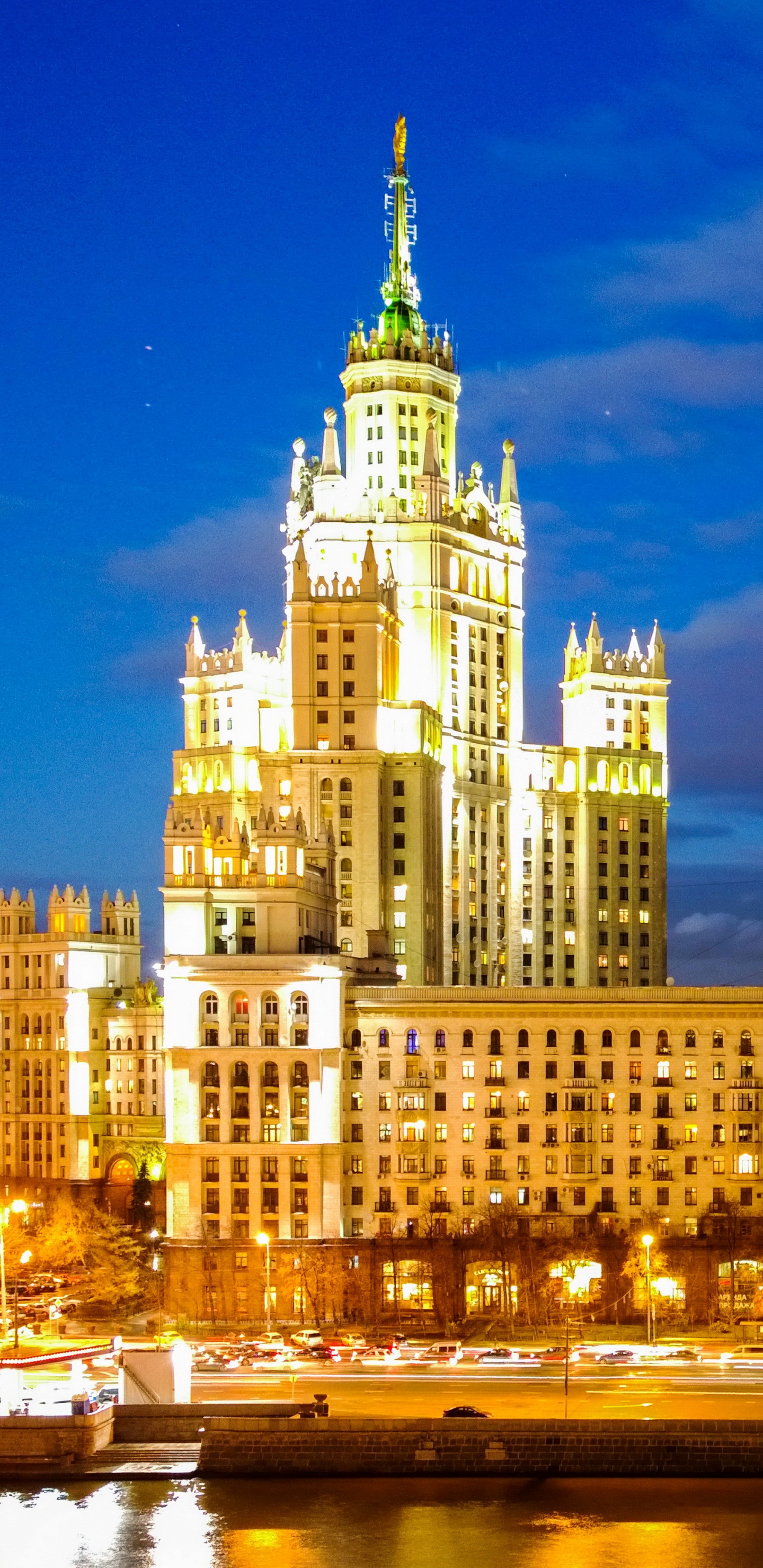 White Concrete Building Near Body of Water During Night Time. Wallpaper in 1440x2960 Resolution