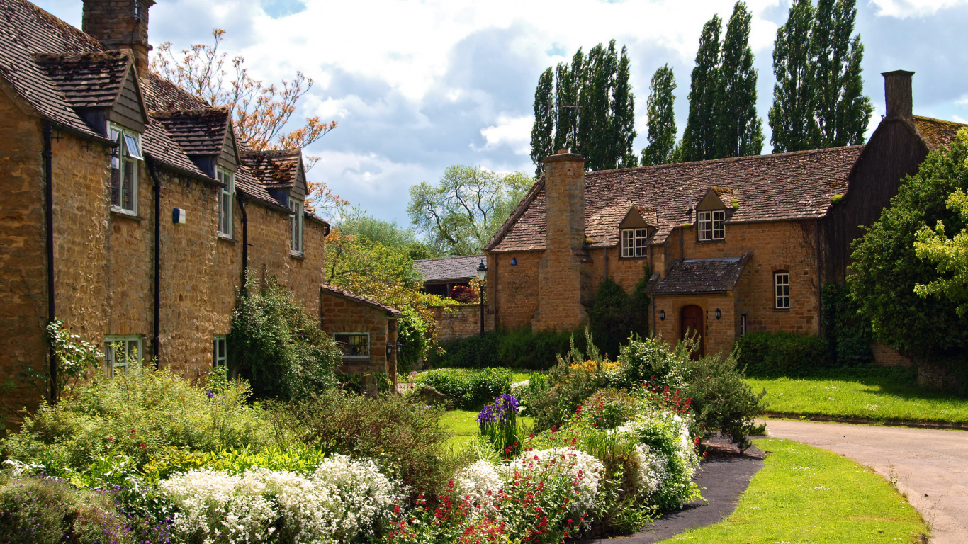 Brown Brick Building Near Green Grass Field Under White Clouds During Daytime. Wallpaper in 1366x768 Resolution
