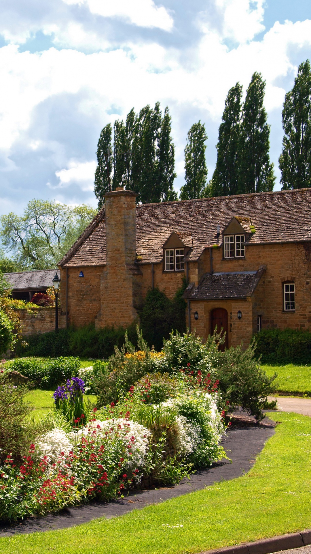 Edificio de Ladrillo Marrón Cerca Del Campo de Hierba Verde Bajo Nubes Blancas Durante el Día. Wallpaper in 1080x1920 Resolution